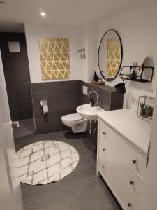 a bathroom with a sink and a toilet and a mirror at Schoberkurve in Raubling