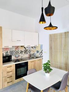 uma cozinha com uma mesa branca com cadeiras e um vaso de plantas em studio Square Funtana em Funtana