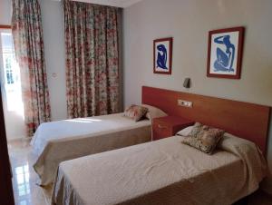 a hotel room with two beds and a window at Casa Tito in Campo Lameiro