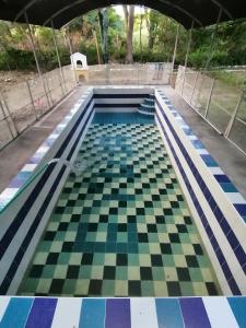 a swimming pool with a checkered floor at Finca turisrica bioaldea eywa todo un oasis in Neiva