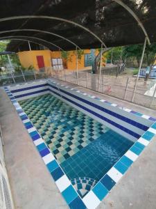 an empty swimming pool with blue and white tiles at Finca turisrica bioaldea eywa todo un oasis in Neiva