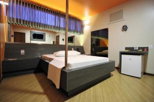 STATUS Motel في بيلو هوريزونتي: غرفة نوم بسرير كبير في غرفة