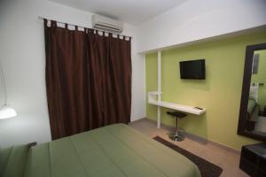 Schlafzimmer mit einem Bett, einem Schreibtisch und einem TV in der Unterkunft Imperial in Milazzo