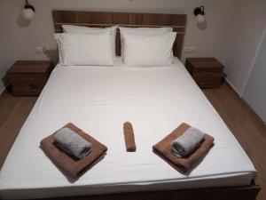 białe łóżko z dwoma ręcznikami na górze w obiekcie SPiROS HOME w Prewezie