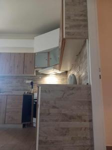 uma cozinha com armários de madeira e uma bancada em SPiROS HOME em Preveza