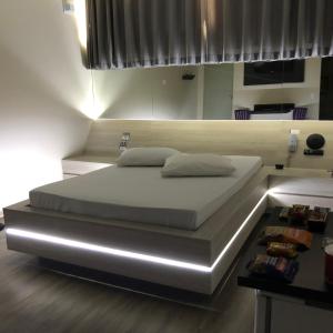 a large bed in a room with a bedvisor at STATUS Motel in Belo Horizonte