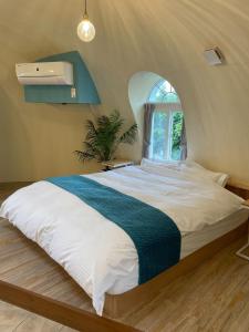 een slaapkamer met een groot bed en een raam bij AYAMARUDO-MU - Vacation STAY 32625v in Amami