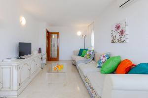 a white living room with a couch and a tv at Mediterranean Blue by Fidalsa in Benidorm