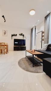 - un salon avec une table et une télévision dans l'établissement La Promesa, à Madrid