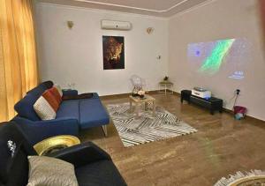 sala de estar con sofá azul y mesa en Luxury Private Pool Villa for families only en Sanad