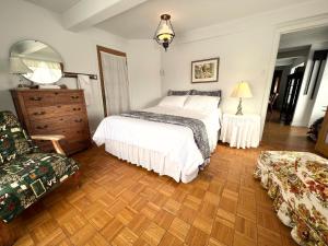 um quarto com uma cama, uma cómoda e uma cadeira em Chalets Montmorency Mont-Sainte-Anne em Saint-Férréol-les-Neiges