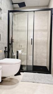 a bathroom with a toilet and a glass shower at La Promesa in Madrid