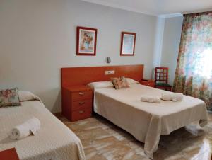 1 dormitorio con 2 camas y toallas. en Casa Tito, en Campo Lameiro