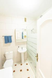 ein weißes Bad mit einem WC und einem Waschbecken in der Unterkunft Nublo in Las Playitas