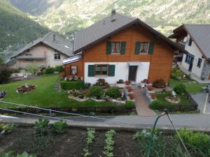 a house with a garden in front of a mountain at Staldenried Ferienwohnung in Staldenried