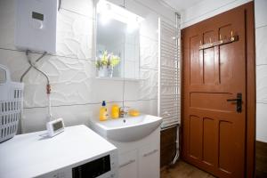 a bathroom with a white sink and a brown door at Cabana Transilvania in Beliş +56 photos