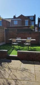 two chairs and a picnic table in a yard at 4 Bedroom, 6 Beds, 3 Bathrooms, Near NEC & Birmingham Airport, Business, Contactor and Family Friendly, Free Wi-Fi, Free Parking in Coventry