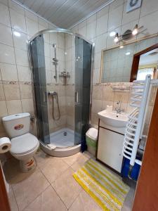 y baño con ducha, aseo y lavamanos. en Pokoje goscinne "U Oli" en Władysławowo