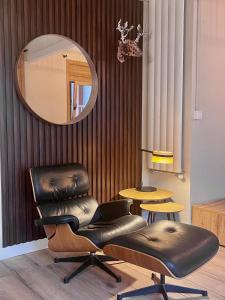 - un fauteuil en cuir et un miroir dans la chambre dans l'établissement Cal Querol - Puigcerdà centre, à Puigcerdà