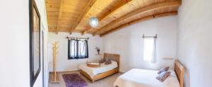 um quarto com 2 camas e um tecto de madeira em Casa Hostal- Cozy Calpulli em Valle de Bravo