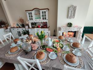 a dining room table with food and a fireplace at Willa SUNRISE in Władysławowo