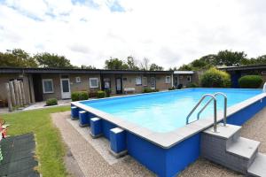 a large blue swimming pool in a yard at Vrijvakantiehuis Houtenburgseweg 2 in Zoutelande