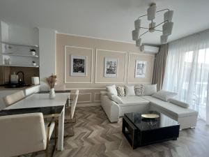a living room with a white couch and a table at GLIM SUITE in Oradea