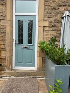 a blue door of a house with a plant and an umbrella at Gorgeous home in Hebden Bridge in Hebden Bridge