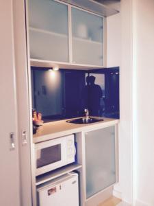 a kitchen with a sink and a microwave at Wytonia Beachfront Accommodation in Port Fairy