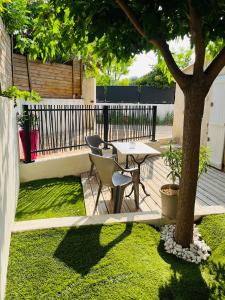 a patio with a table and chairs next to a tree at Au charme provençal in Allauch