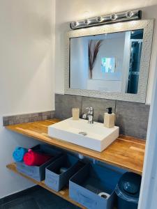 a bathroom with a white sink and a mirror at Au charme provençal in Allauch