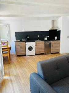 a living room with a washing machine and a couch at Au charme provençal in Allauch