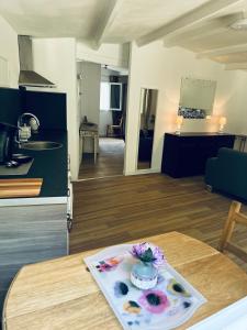 una cocina y una sala de estar con una mesa con un jarrón. en Au charme provençal en Allauch