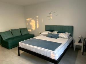 a bedroom with a bed and a green couch at Pokoje Victoria in Ustka