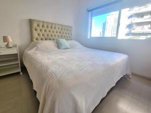 1 dormitorio con cama blanca y almohada azul en Cómodo monoambiente en Palermo cama King Seguridad 24 h en Buenos Aires