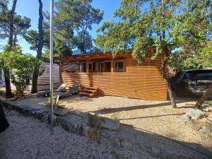 a log cabin with a car parked in front of it at Camping Park Soline - Rose PB -Mobile Home in Biograd na Moru