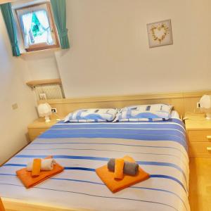 ein Schlafzimmer mit einem Bett mit orangefarbenen Handtüchern darauf in der Unterkunft P&F Apartment Ortisei in St. Ulrich in Gröden