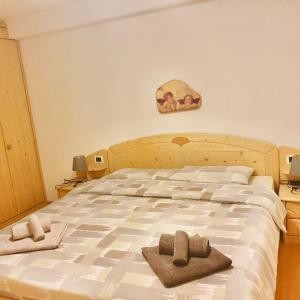 ein Schlafzimmer mit einem großen Bett mit Handtüchern darauf in der Unterkunft P&F Apartment Ortisei in St. Ulrich in Gröden
