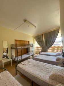 1 Schlafzimmer mit 3 Etagenbetten und einem Fenster in der Unterkunft Garden Hostel in Aradas