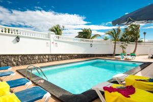 een zwembad met stoelen en een villa bij Villa Ramos Dos in Puerto Calero