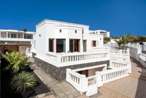 een groot wit huis met een groot balkon bij Villa Ramos Dos in Puerto Calero