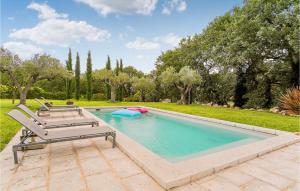 uma piscina com 2 espreguiçadeiras e um macarrão de piscina em 3 Bedroom Stunning Home In Aix-en-provence em Aix-en-Provence