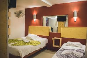 a hotel room with two beds and a mirror at Hotel La Casona Iquitos in Iquitos