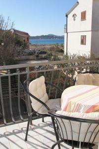 d'une terrasse avec une chaise et une table sur un balcon. dans l'établissement Sea view and beach apartament Green, Petar House, à Vodice