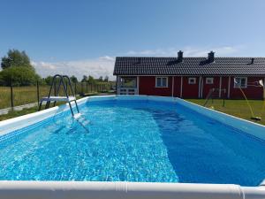 a swimming pool with a slide in front of a house at Domki Valhalla Polna 8a Chłopy Sarbinowo in Chłopy