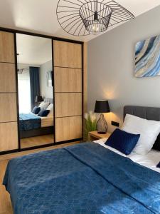 ポゴジェリツァにあるBaltic Maritimoのベッドルーム(青いベッド1台、鏡付)