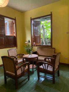 Pokój ze stołem, krzesłami i oknem w obiekcie Villa Sambal w mieście Yogyakarta