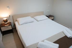 a bedroom with a large white bed with two pillows at Lovos House in Laganas +31 photos