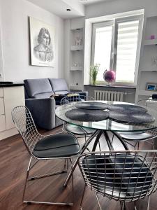 a living room with a glass table and chairs at Space Apartment 2 rooms Center in Warsaw