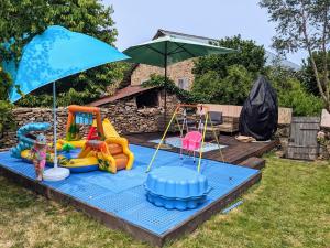 a play area with toys and an umbrella at Chez Elle in Rancon